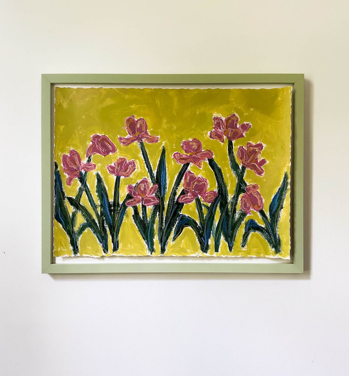 Framed artwork of pink flowers on a yellow background