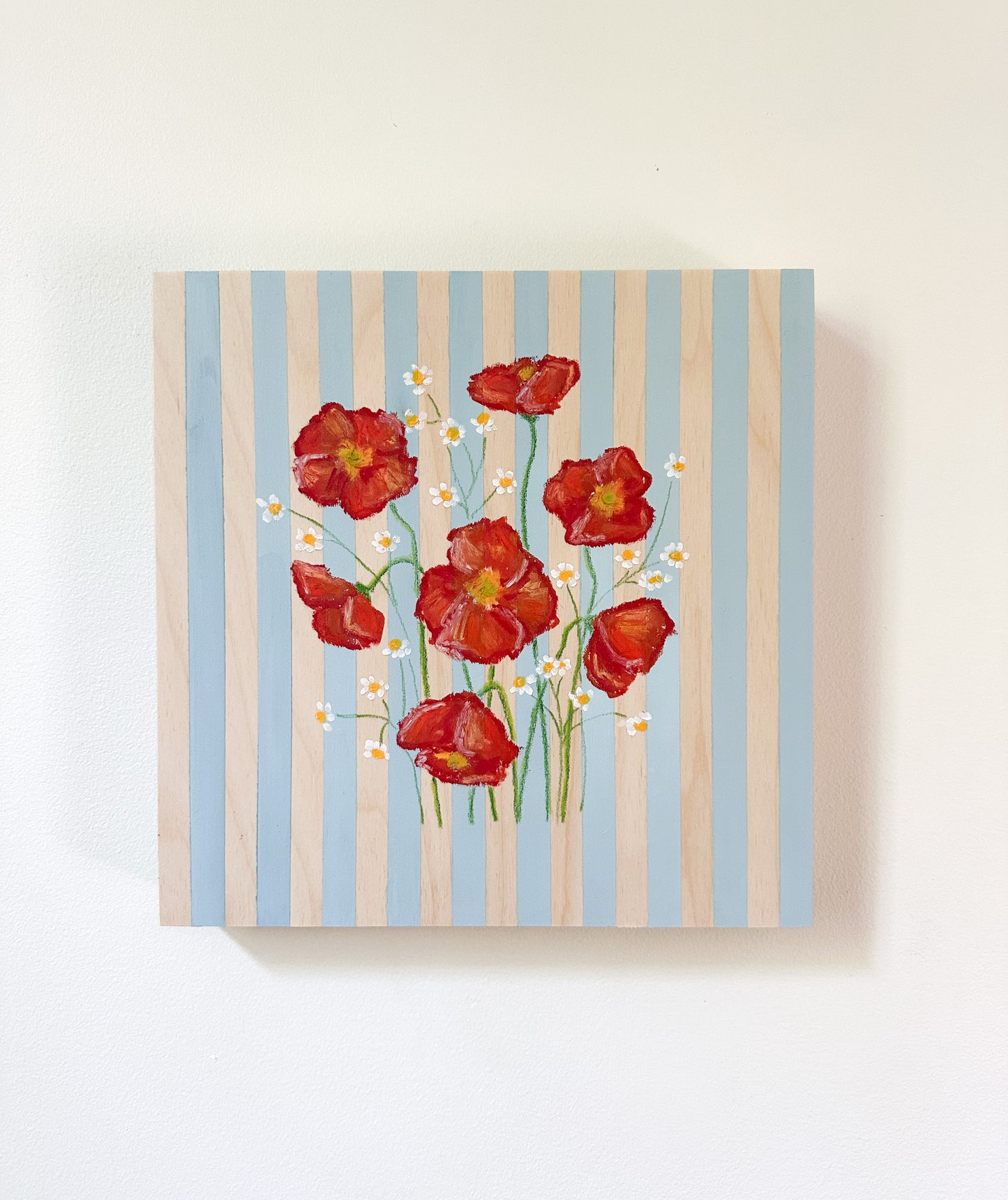 Framed artwork of red flowers on a striped background
