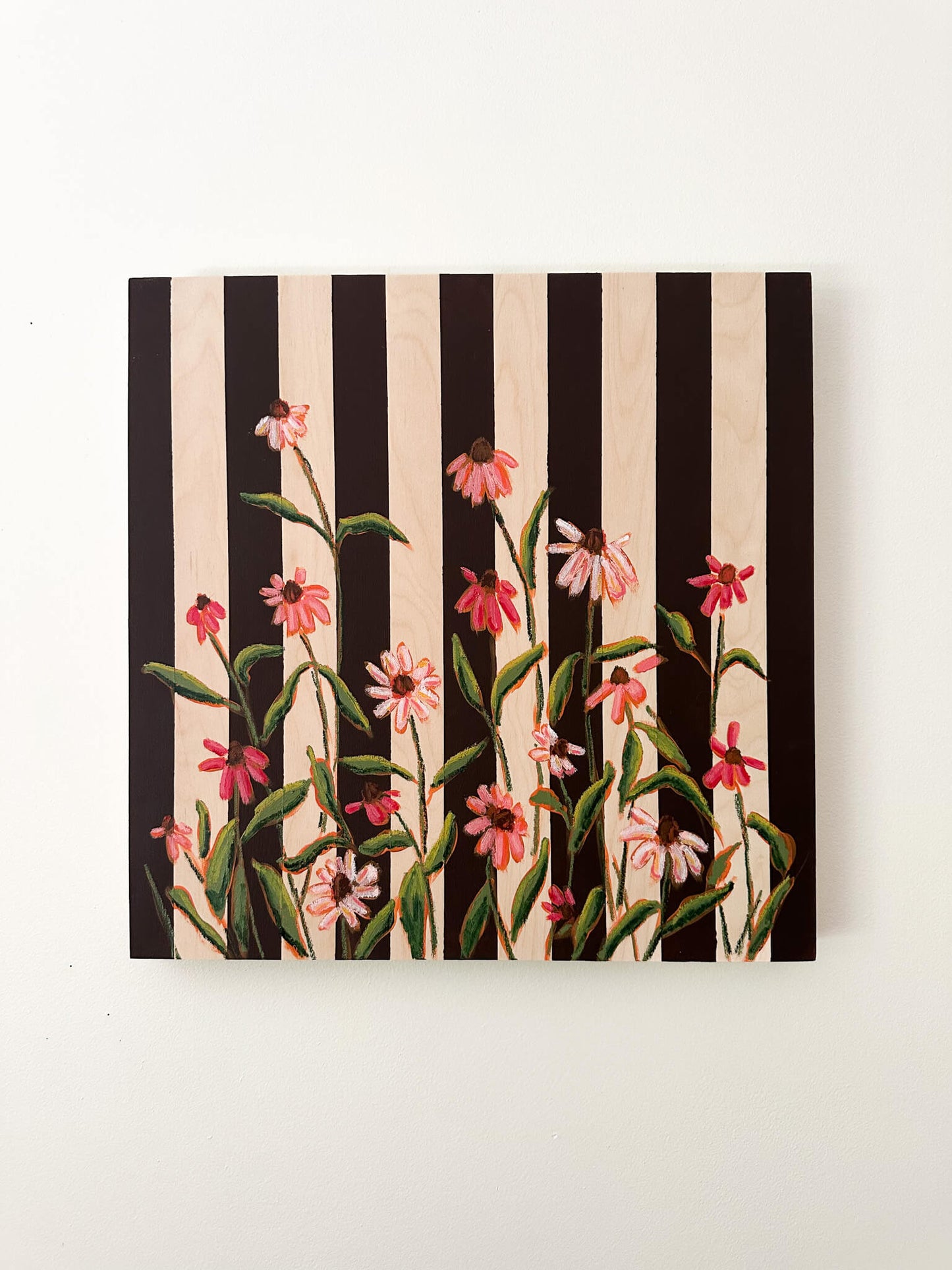 Floral pattern with pink flowers and green leaves on a black and white striped background