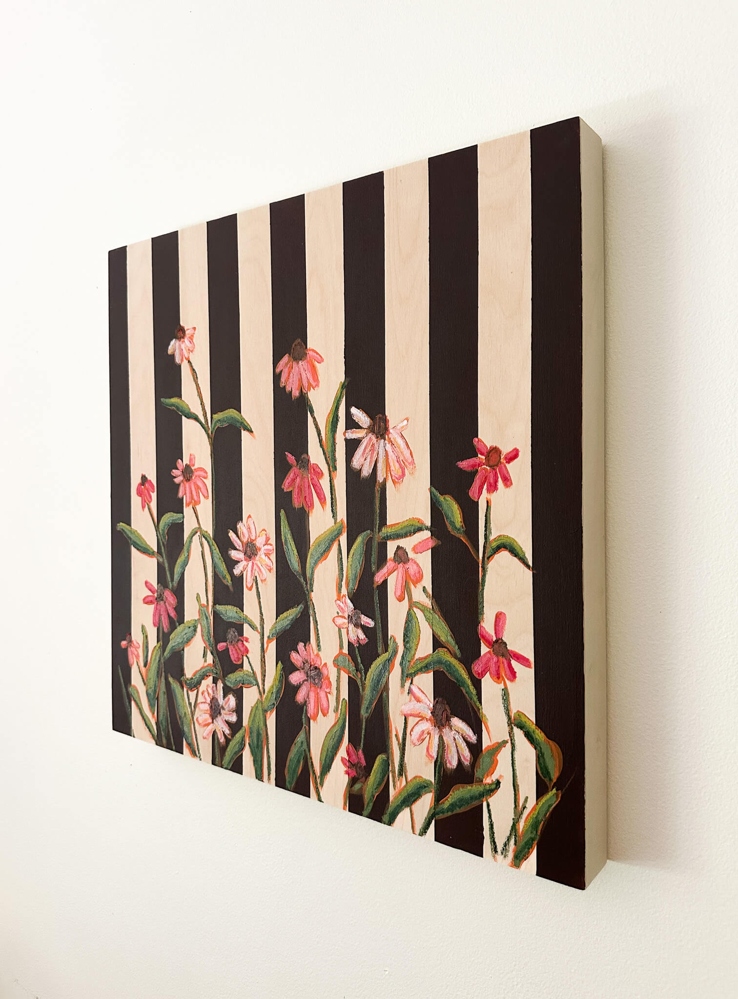 Floral pattern with pink flowers and green leaves on a black and white striped background