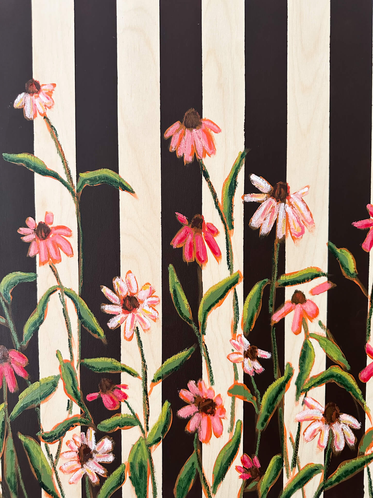 Floral pattern with pink flowers and green leaves on a black and white striped background