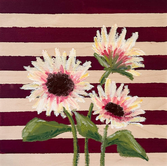 Oil pastel painted sunflowers painted on a red and wood striped, painted wood panel.