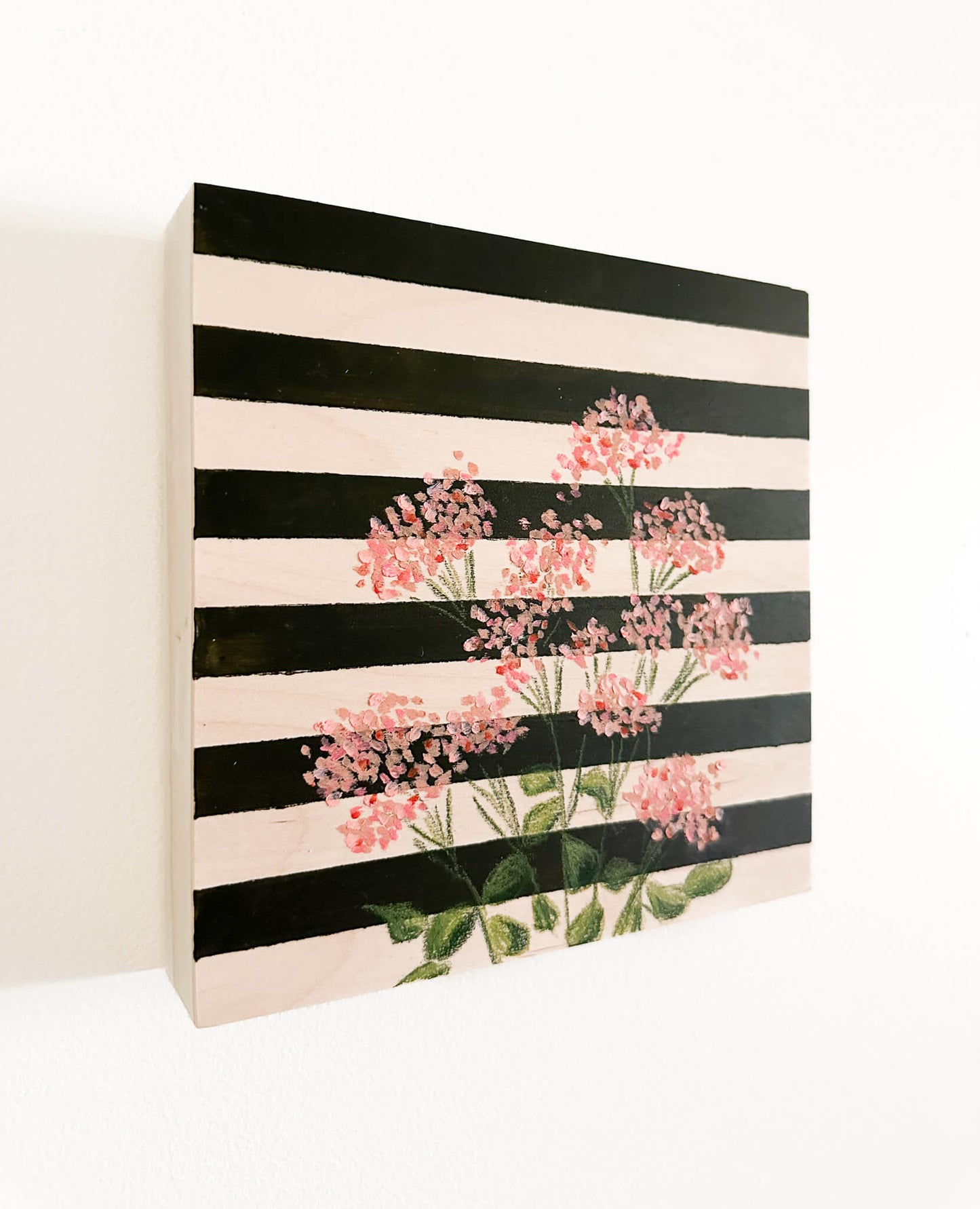 pink oil pastel florals on a very dark green and wood striped wood panel.