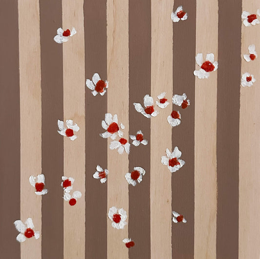 Pattern of white flowers with red centers on brown and wood striped wood panel