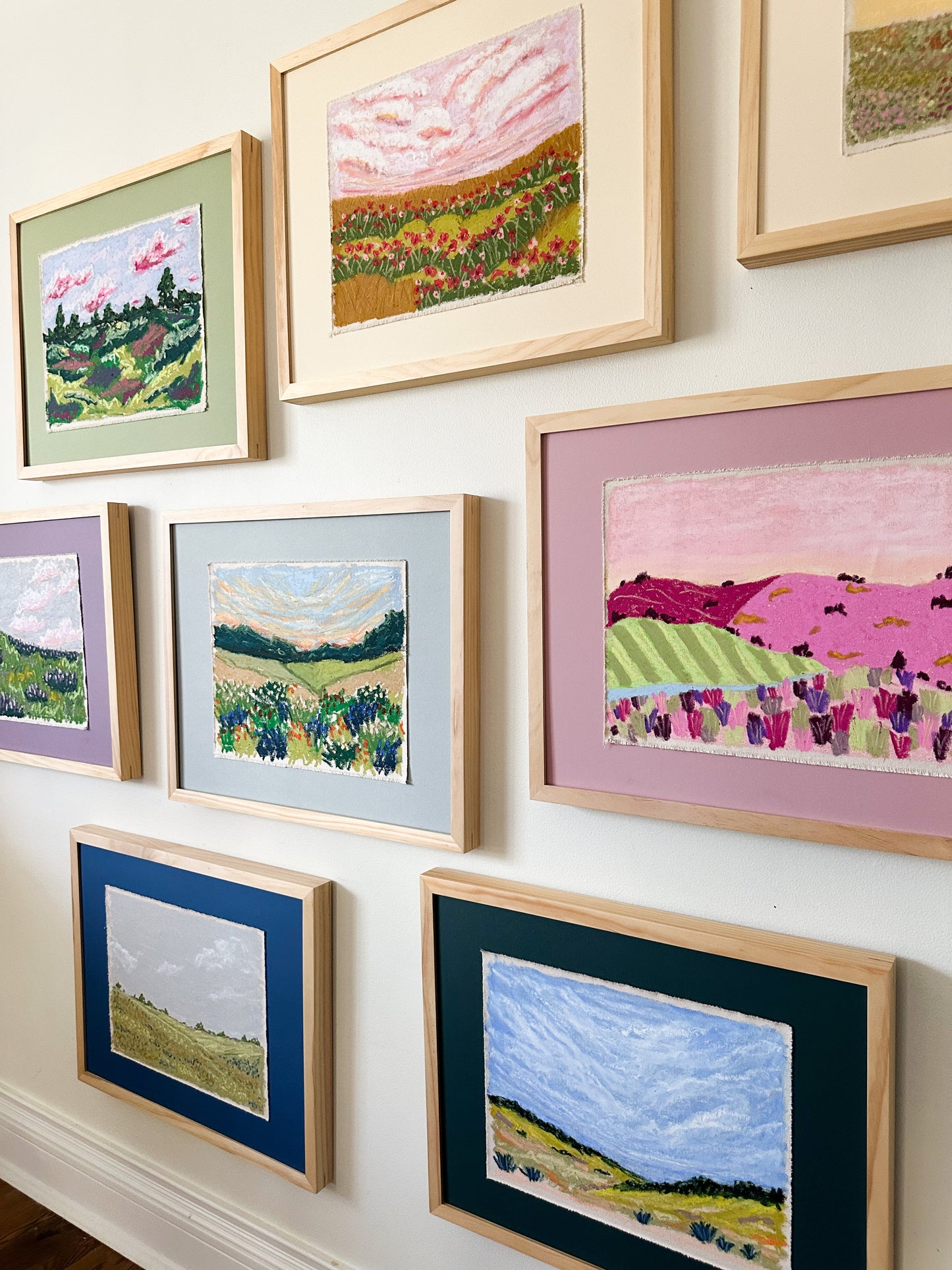 Collection of framed landscape paintings on a wall