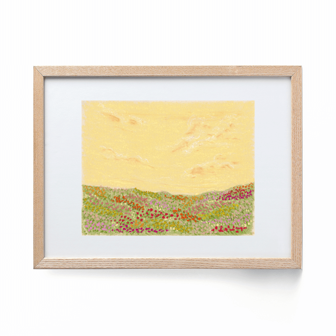 A colorful landscape print framed in a wood frame. The print shows a colorful flower field with a yellow sky.