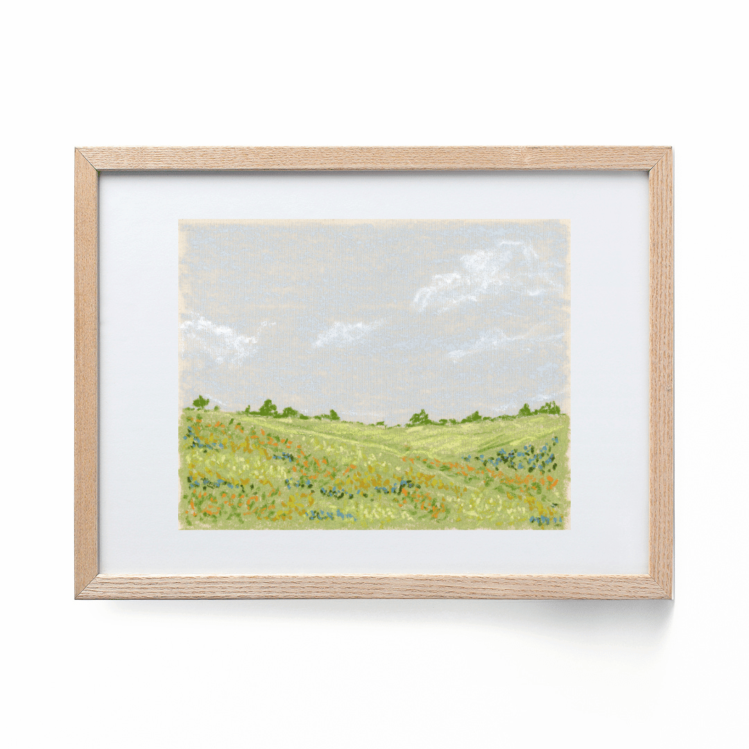 An landscape art print framed in a wooden frame.