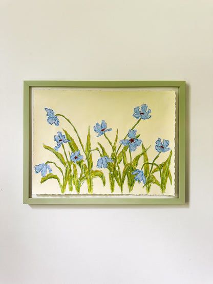 Framed artwork of blue flowers on a yellow background