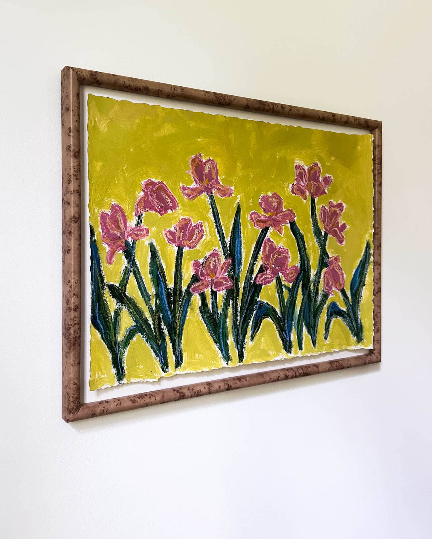Framed artwork of pink flowers on a yellow background