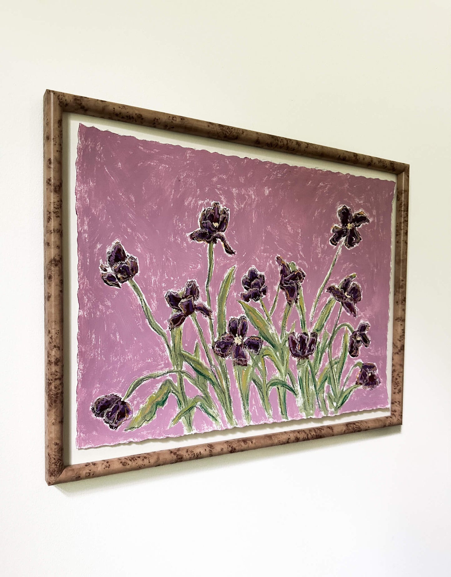 Framed artwork of purple flowers on a pink background