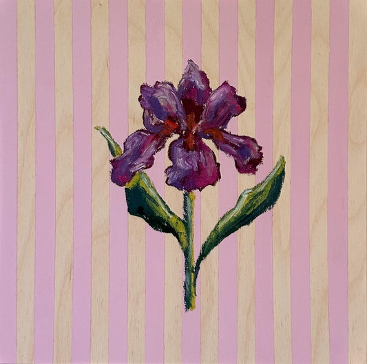 Purple flower with green stem on a striped pink and wood background