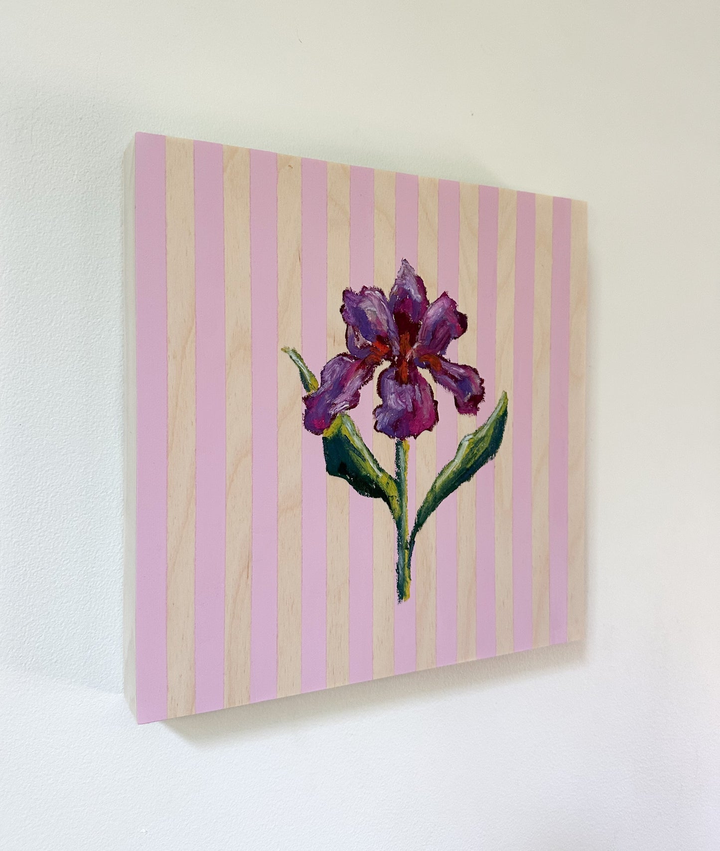 Painting of a purple flower on a pink and beige striped background