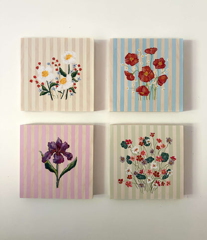 Four floral-themed wall art pieces on a white background