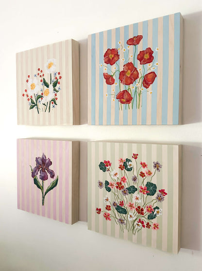 Set of four floral-themed wall art pieces with striped backgrounds.