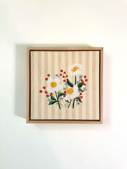 Framed artwork with floral design on a striped background