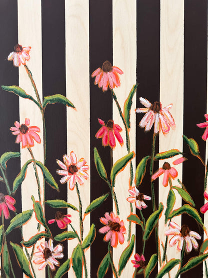 Floral pattern with pink flowers and green leaves on a black and white striped background
