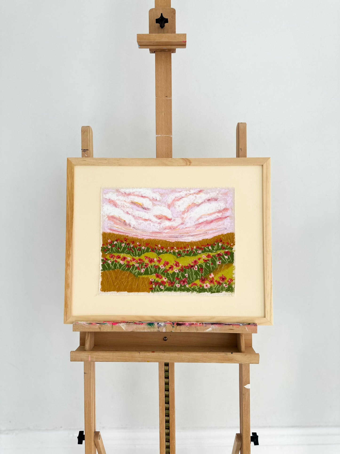 Painting of a landscape on an easel against a white background