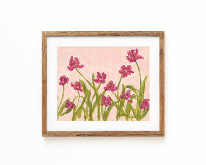 An art print of pink flowers on a pink background framed in a natural wood frame and displayed against a white backdrop.