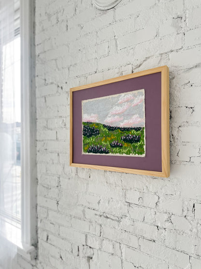 Framed artwork on a white brick wall