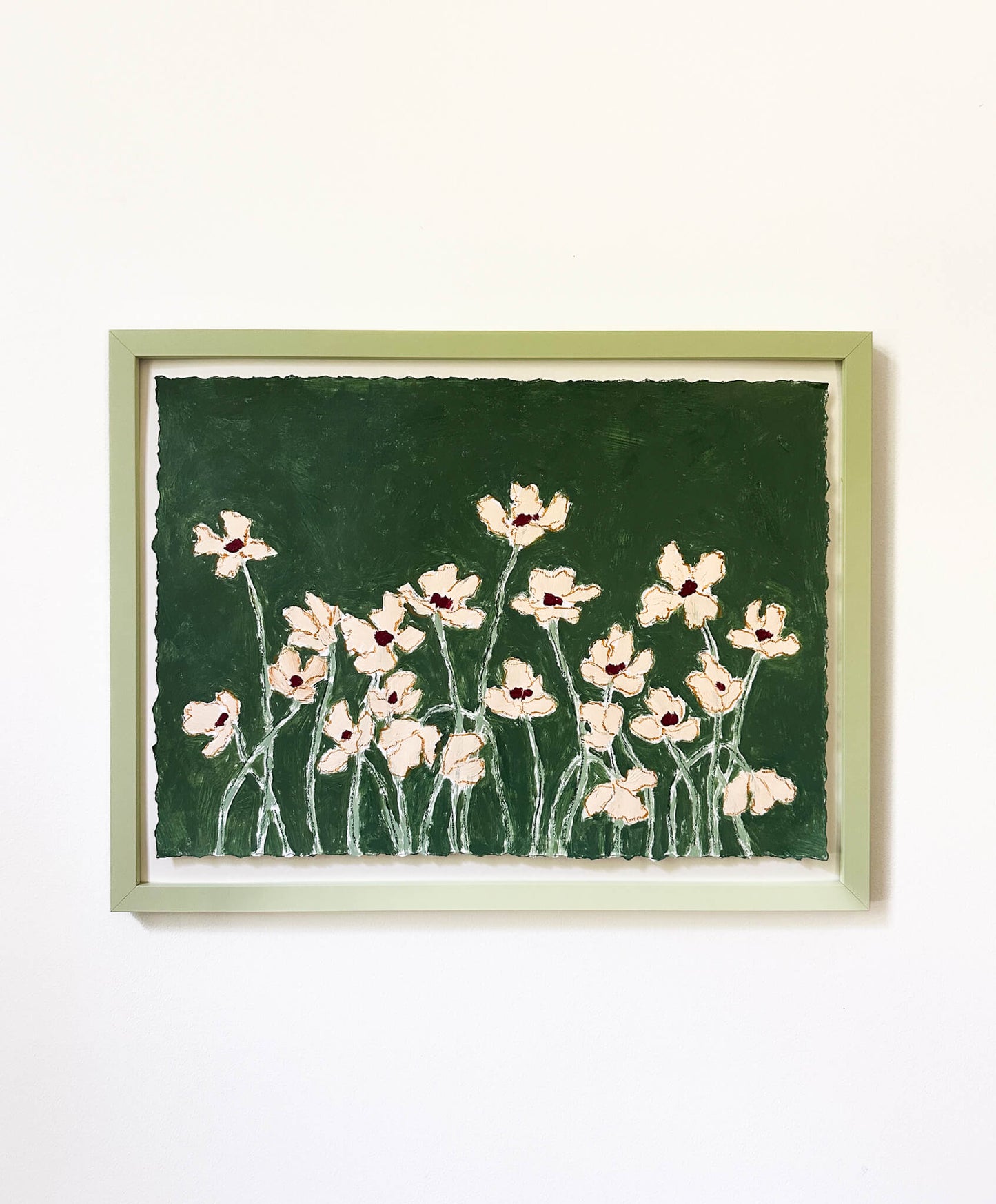 Framed artwork of pink flowers on a green background