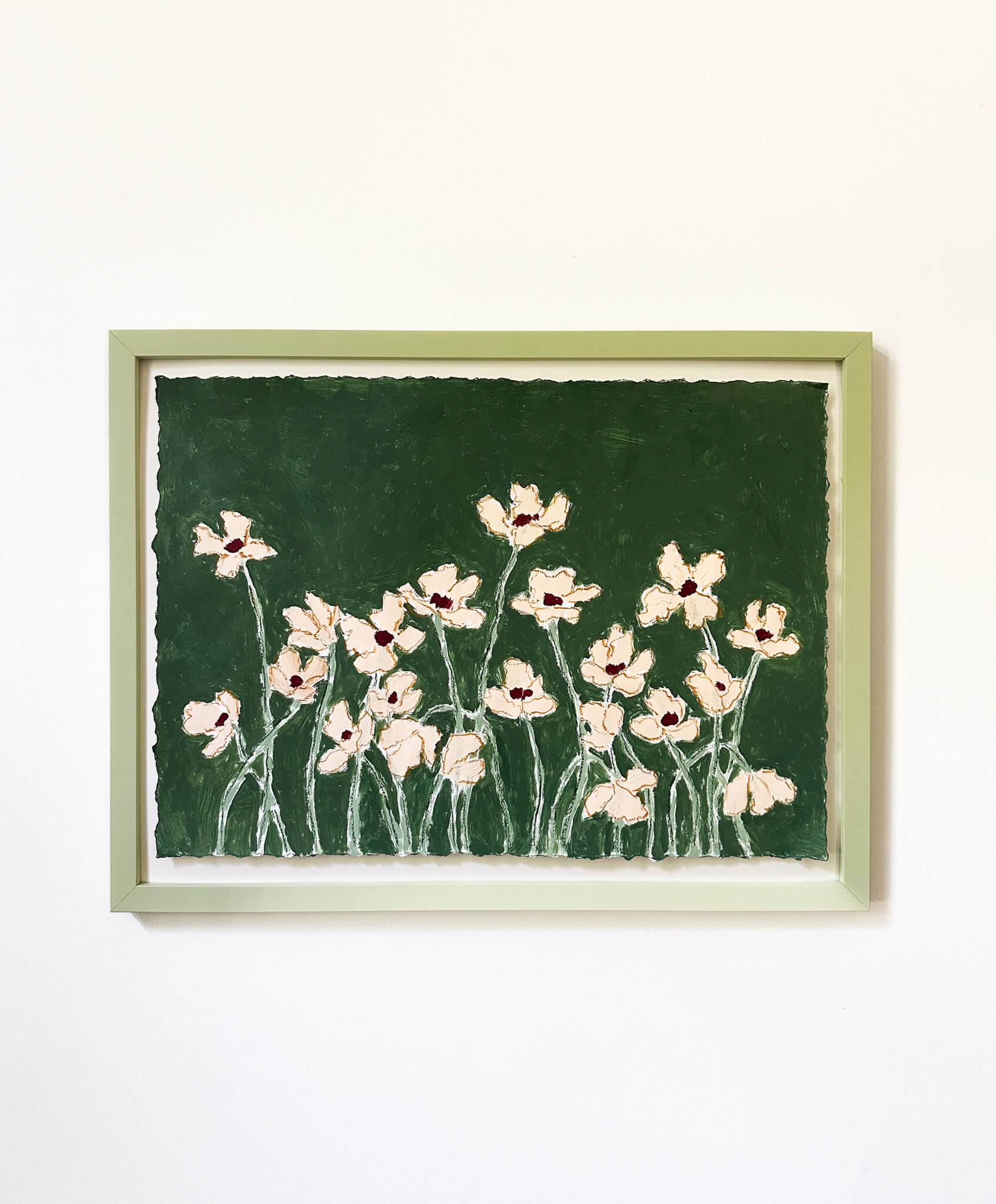Framed artwork of pink flowers on a green background