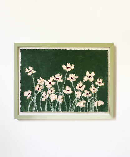 Framed artwork of pink flowers on a green background