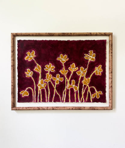 Framed artwork with gold floral design on a red background