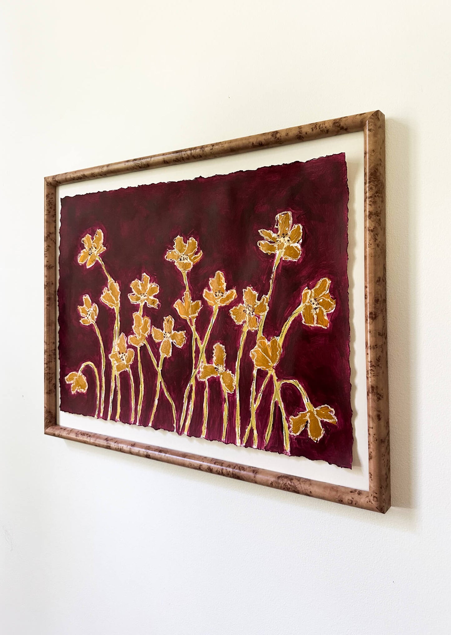 Framed artwork with gold floral design on a red background