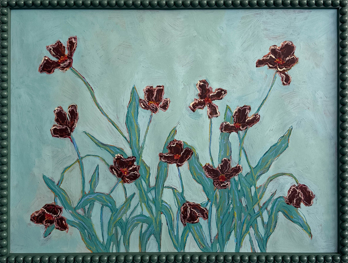 A painting of deep red flowers with teal leaves on a light teal background and framed in a dark teal bobbin frame. 