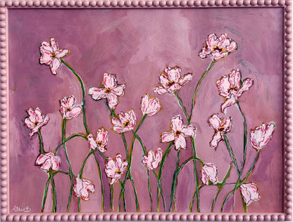 A painting of light pink flowers with green stems on a pink background and framed in a light pink bobbin frame. 