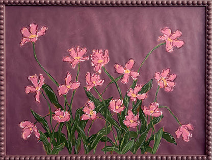 A painting o pink flowers with green leaves on a  plum background framed in a plum bobbin frame.