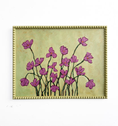 A painting of deep pink flowers with green stems  on a chartreuse background framed in a chartreuse green bobbin frame hanging on a white wall. 