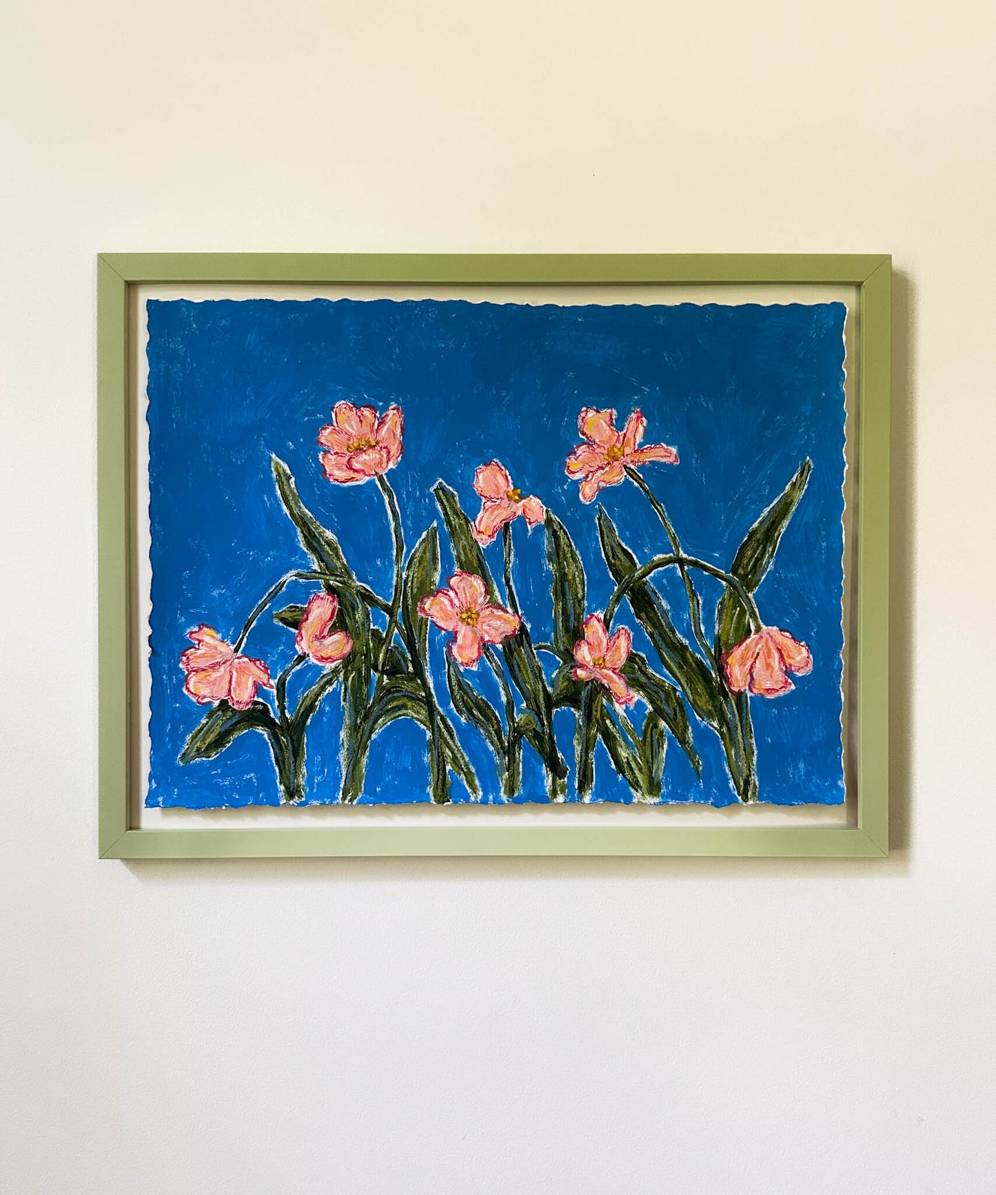 Framed artwork of pink flowers on a blue background