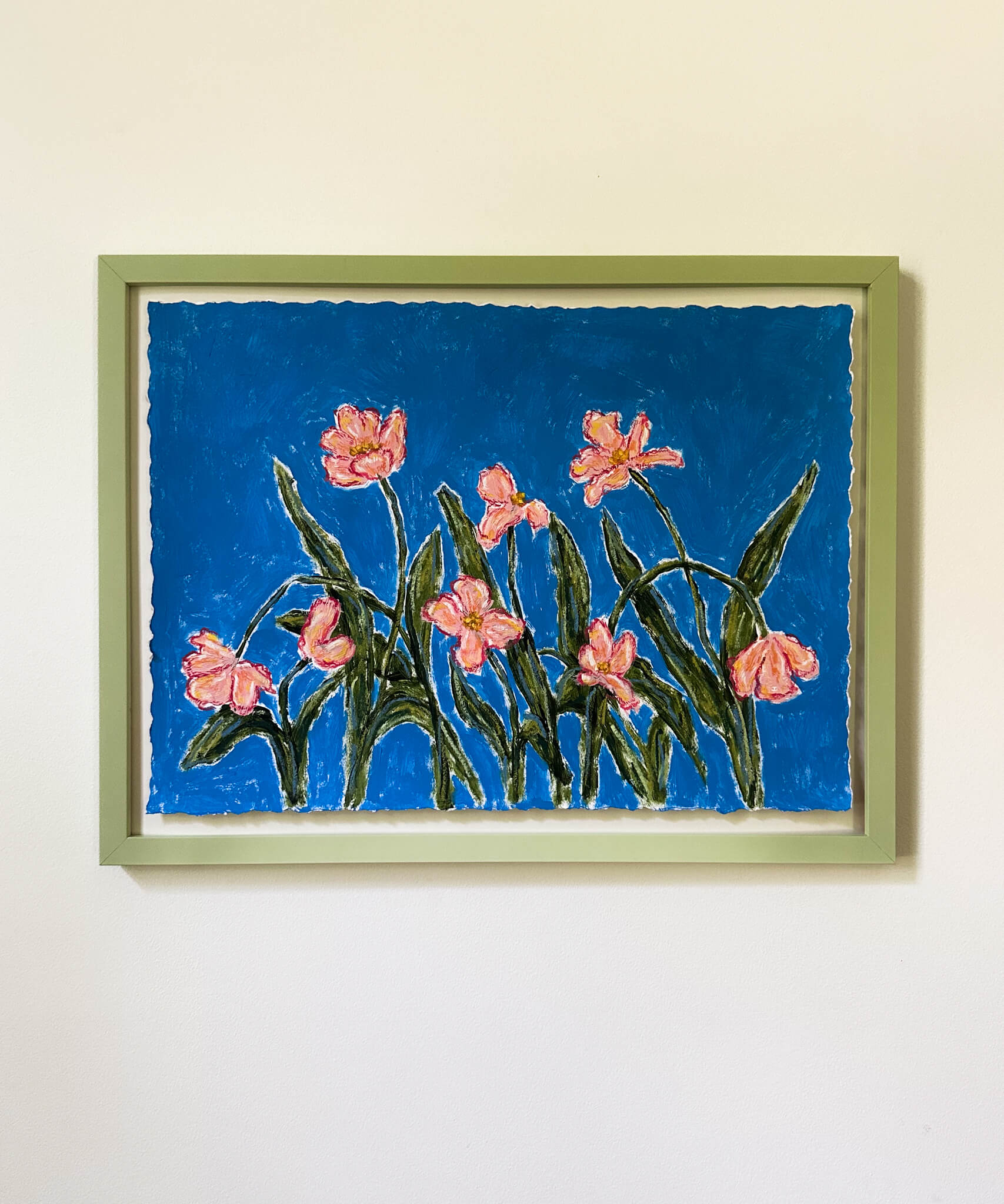 Framed artwork of pink flowers on a blue background