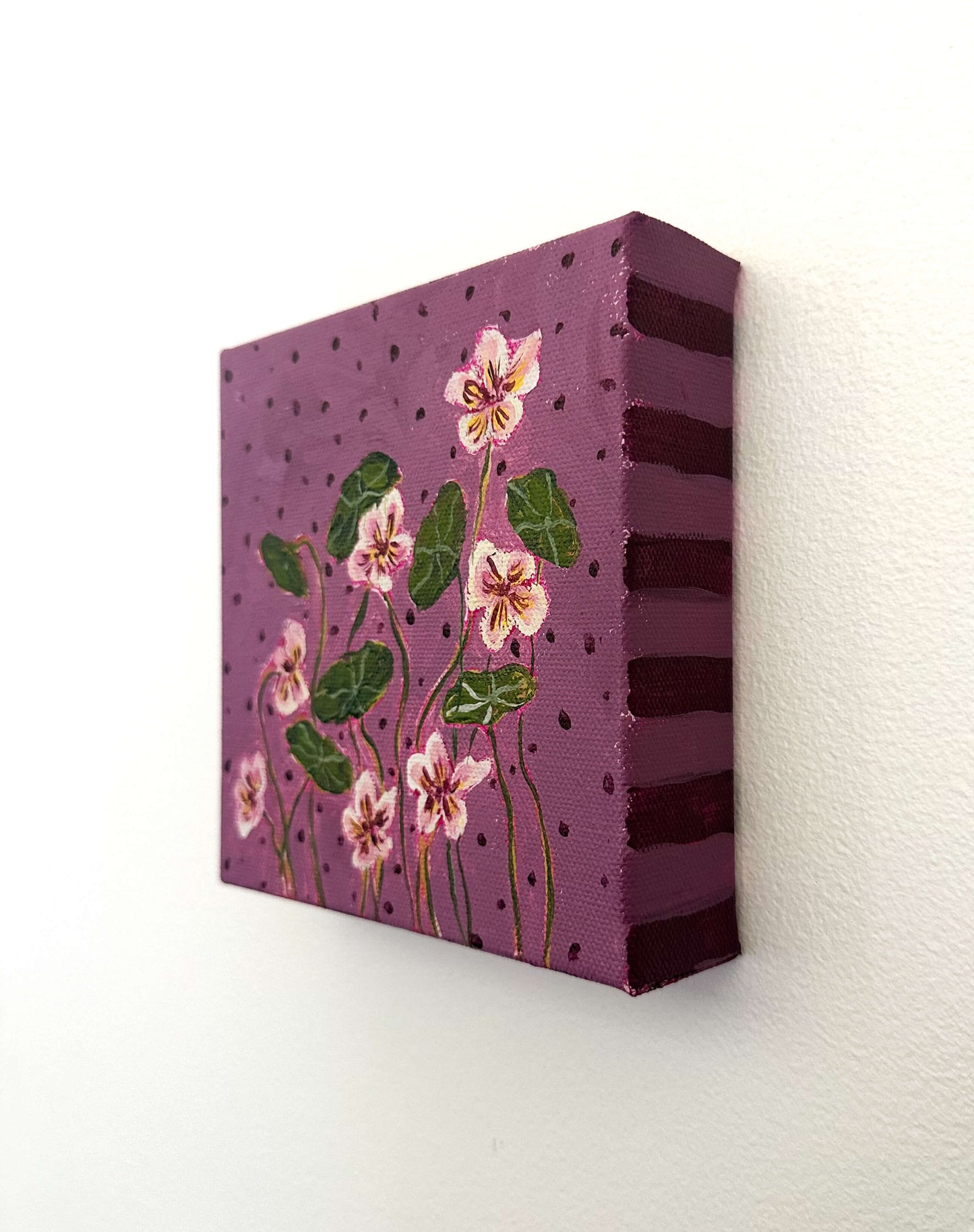 Canvas painting with floral design on a purple background