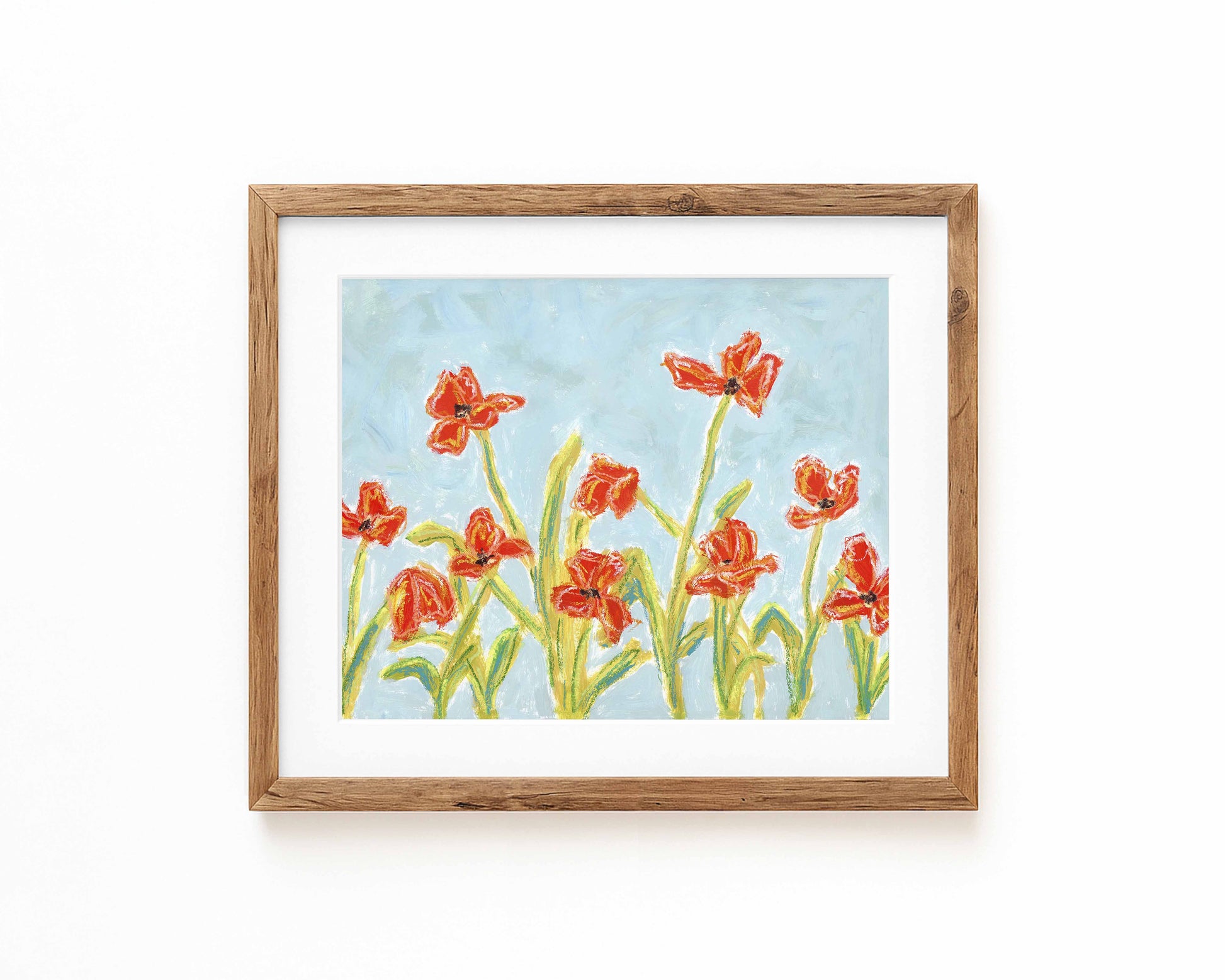 A print of orange flowers on a blue background framed in a wood frame.