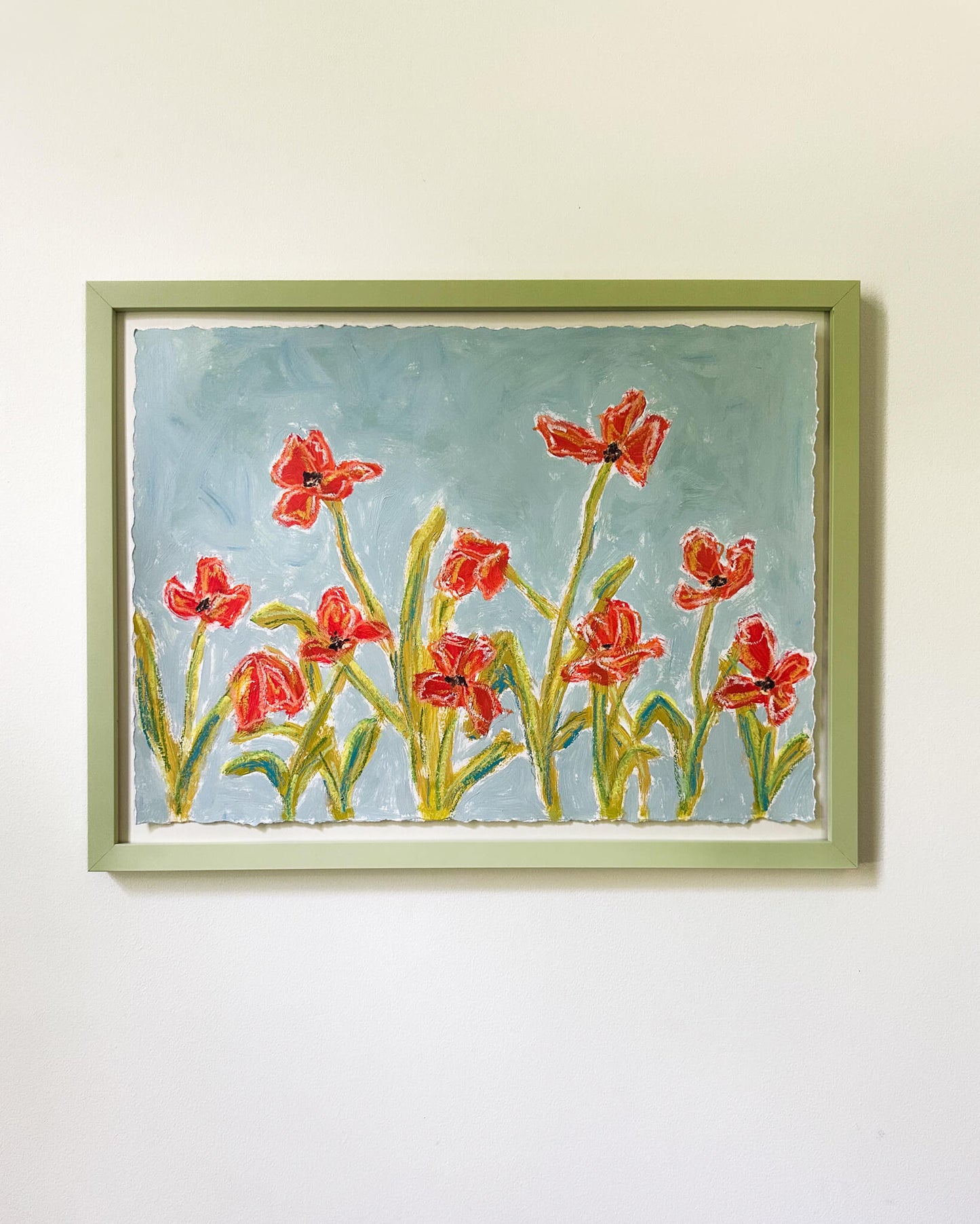 Framed painting of red flowers on a light blue background