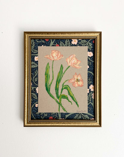 peach florals painted with oil pastels on tan paper, mounted on floral fabric and framed in a gold frame. Painting shown on a white wall