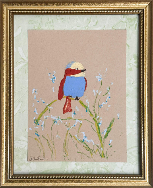 A painting of a colorful bird perched on a plant painted on tan paper and mounted on light green fabric. The painting is in a gold frame. 