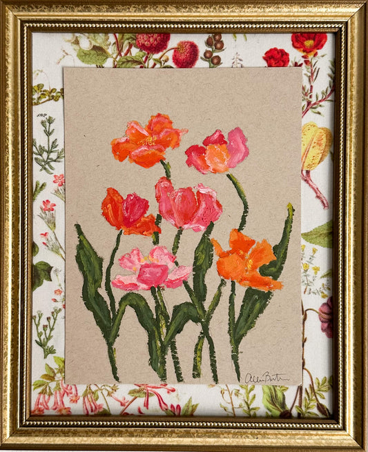 A painting of pink and orange flowers on tan paper mounted on floral fabric. The painting is in a gold frame.