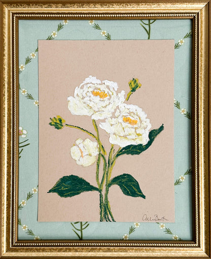 A painting of white peonies on tan paper mounted on floral fabric. The painting is in a gold frame.