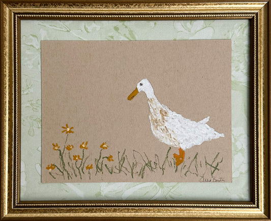 A painting of a goose with flowers on tan paper mounted on light green fabric. The painting is in a gold frame.