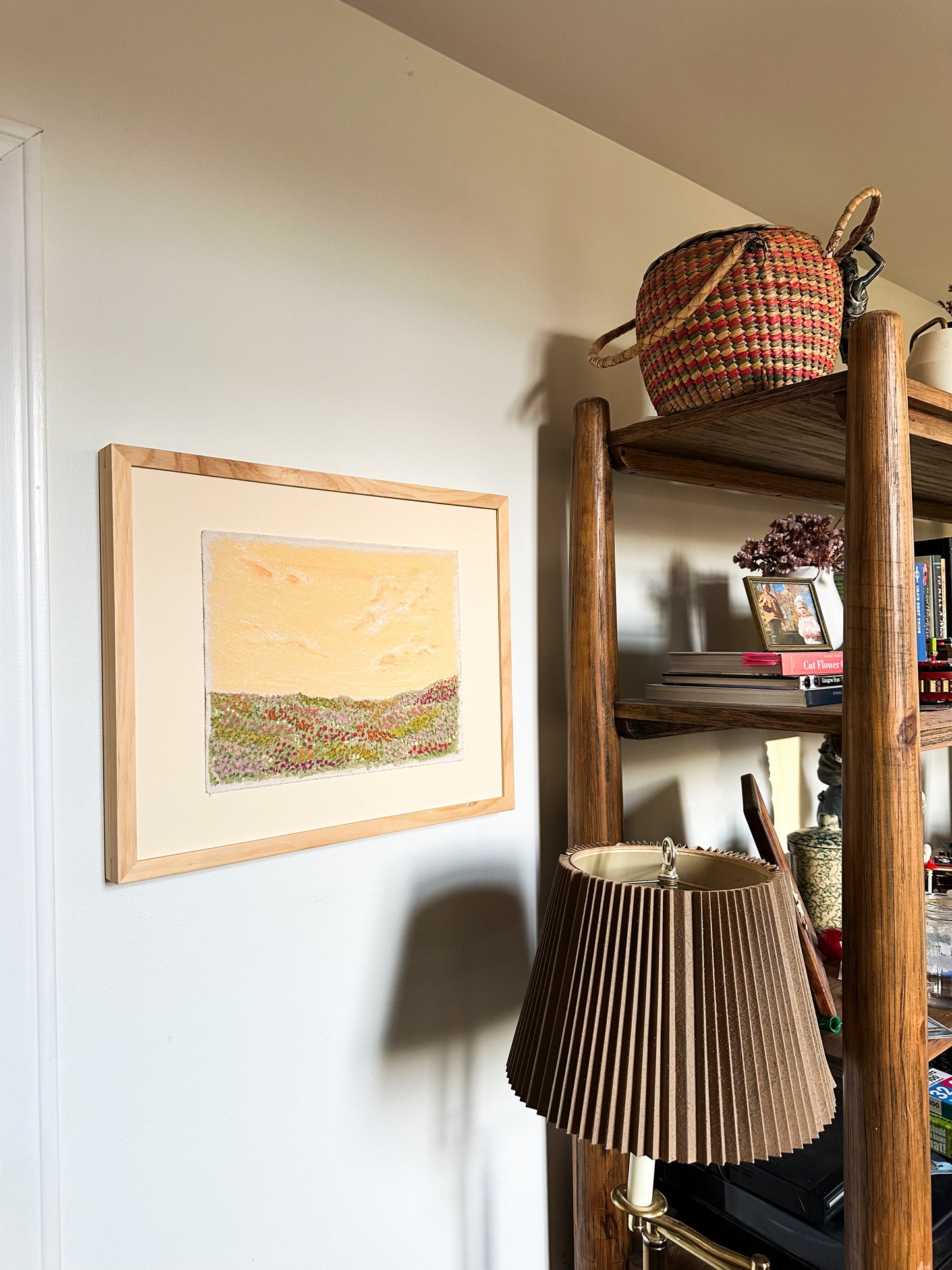 Wooden shelf with decorative items against a wall with a framed picture