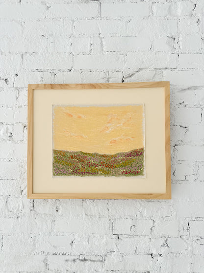 Framed landscape artwork on a brick white wall