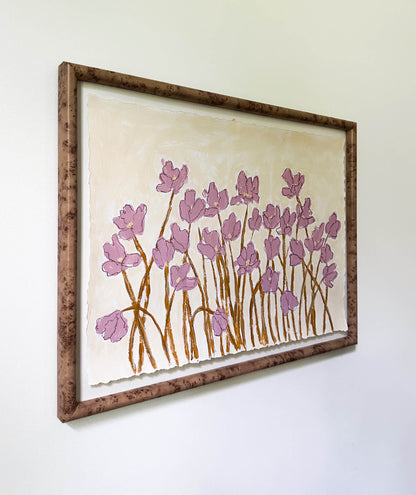 Framed artwork of pink floral design on a white wall