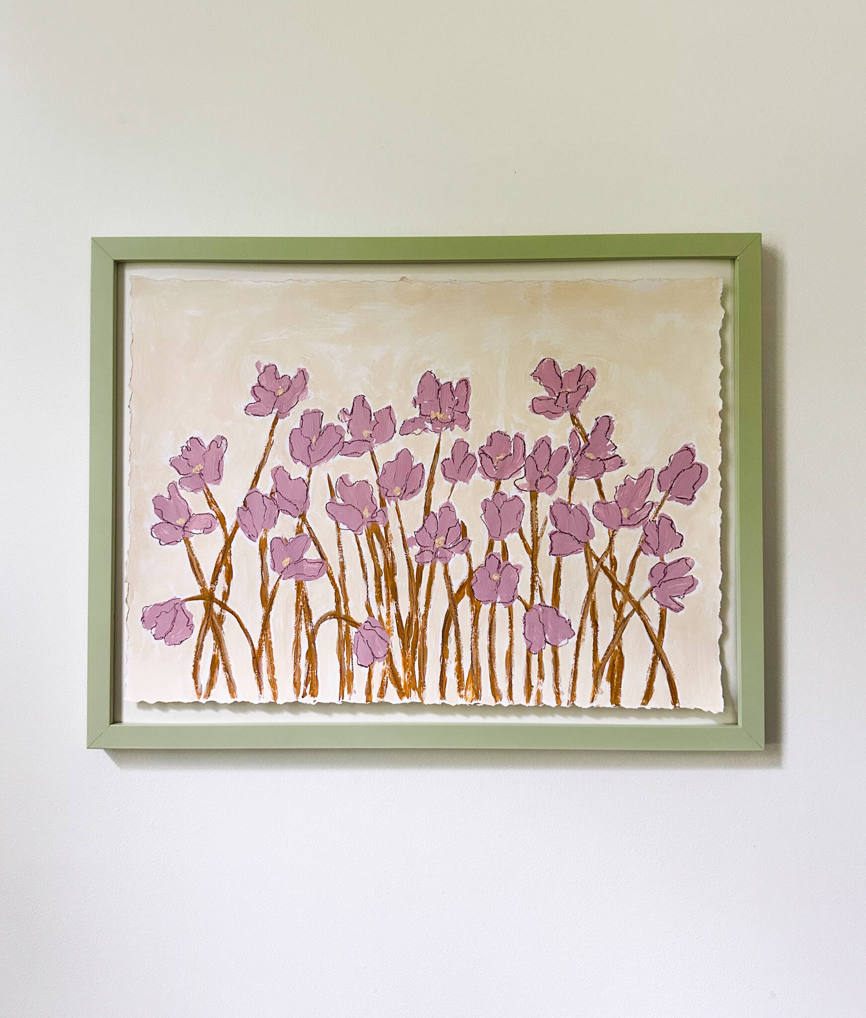 Framed artwork of pink floral design on a white wall