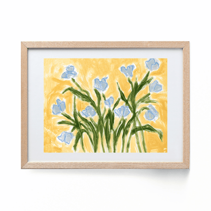 blue tulips on a yellow background framed in a wood frame