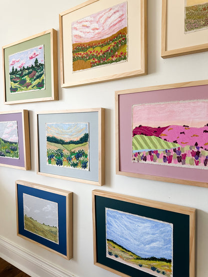 Collection of framed landscape paintings on a wall