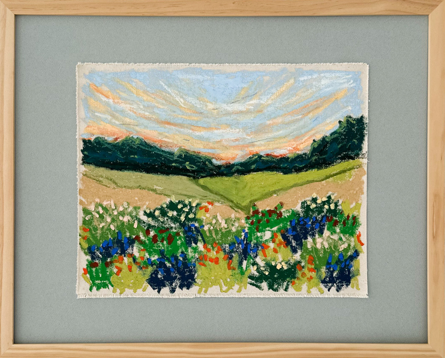 Framed artwork of a landscape with fields and flowers on a dusty blue background