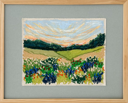 Framed artwork of a landscape with fields and flowers on a dusty blue background
